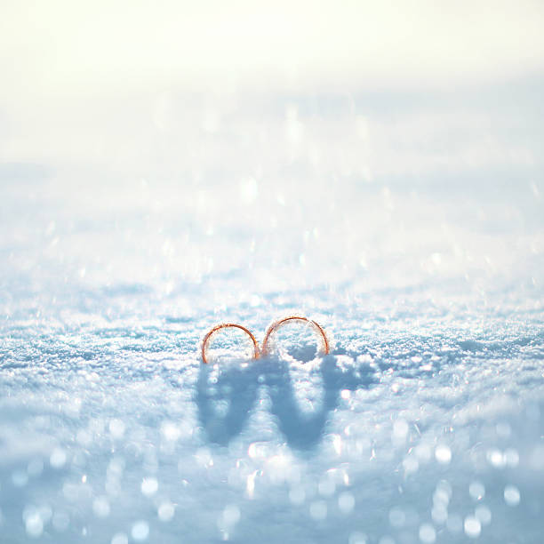 Wedding gold rings on the snow in winter day stock photo
