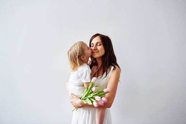 Woman enjoying kiss from her little daughter on Mother's Day