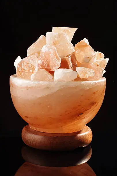 Photo of Himalayan salt lamp isolated on the black background