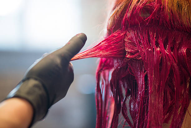 Woman Getting Hair Dyed Red stock photo