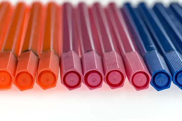 Colored pens lying on a white background