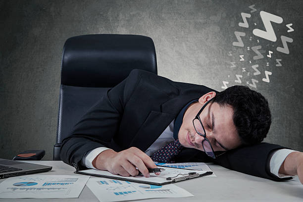 istock Businessman lying on desk with closed eyes 537016603