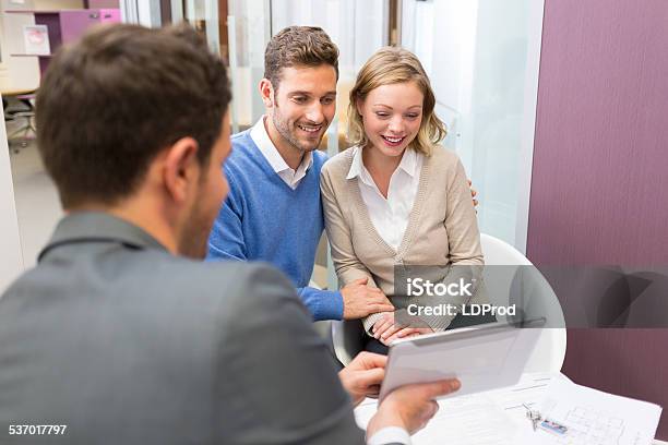 Couple Meeting Realestate Showing A House Project On A Tablet Stock Photo - Download Image Now