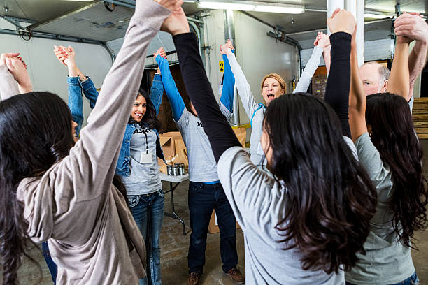 istock Team of volunteers holding hands in celebration 537019451