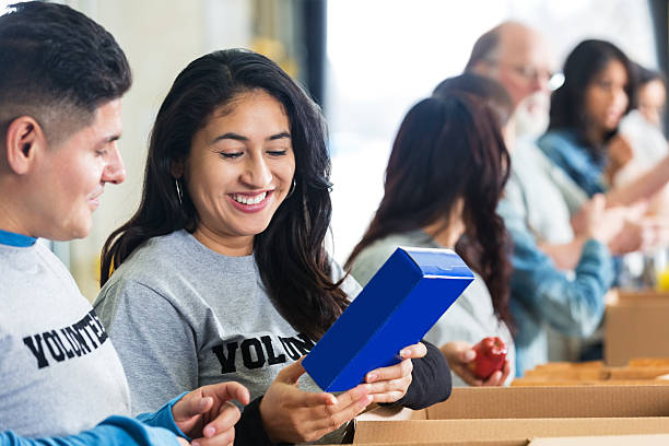 istock Hispanic couple sorting donated food while volunteering together 537019473
