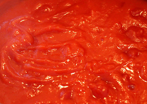 Image of homemade tomato sauce for pasta, ragu sauce cooking Photo showing some homemade tomato sauce / ragu sauce cooking in a saucepan, pictured simmering away and reducing on a low heat.  This is a rich pasta sauce made with tomatoes, tomato puree, finely chopped onion and lots of freshly picked herbs. marinara stock pictures, royalty-free photos & images