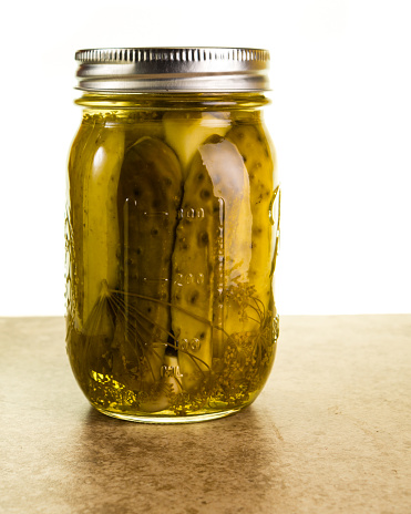 Homemade dill pickles in mason jars on a kitchen counter