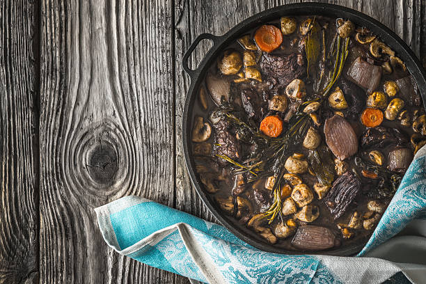 istock Beef bourguignon in a cast iron pan on wooden boards 537058608