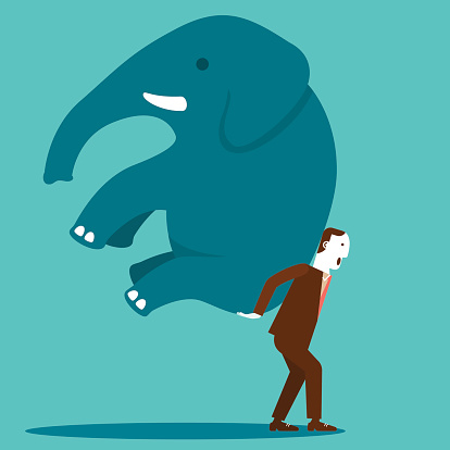 A businessman carrying an elephant on his back and moving with determination.