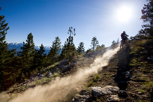 A male motocross rider heads to the top of a climb while riding a trail in British Columbia, Canada.