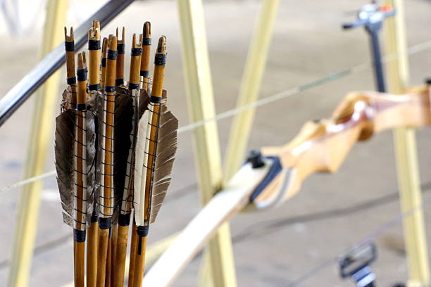 A close up picture of traditional arrows and a bow for competition in the background