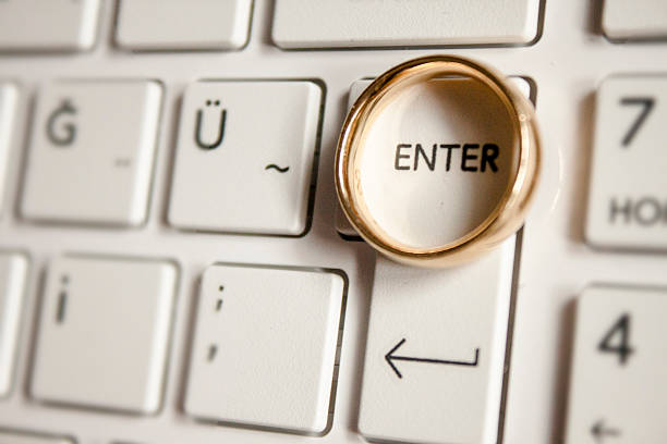 Wedding ring on keyboard keys inside enter stock photo