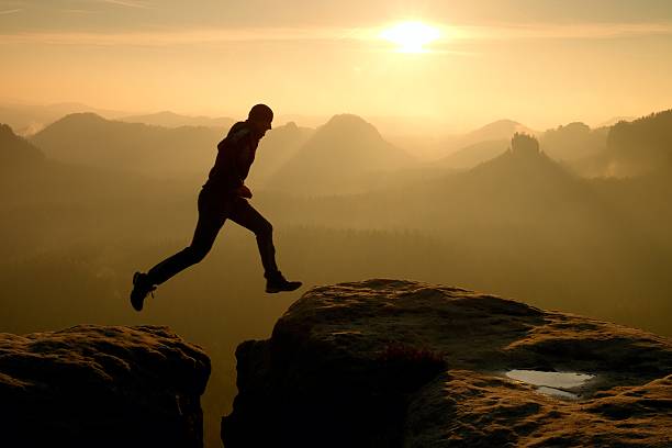 istock Crazy hiker jump between cliffs. Amazing mountains, heavy mist 537065330