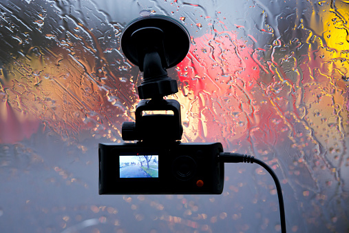 Vehicle DVR on glass of car in rain lights reflection