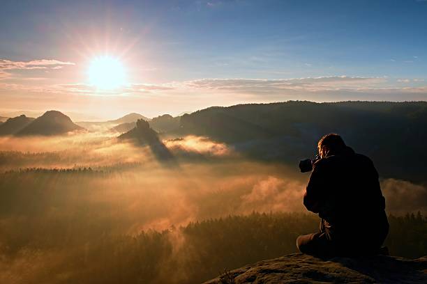 istock Happy tourist with camera watching into colorful misty  morning 537068512