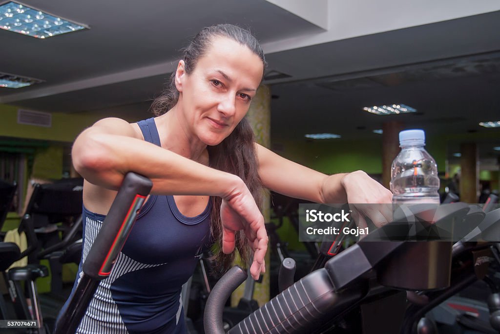 Resting in gym Attractive woman resting on exercise bike and looking at camera 2015 Stock Photo