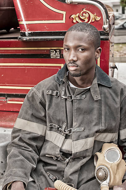 Black African American Firefighter From 1940 to 1960, Fire Truck. Black African American Firefighter From 1940 to 1960, Fire Truck. 1930s style men image created 1920s old fashioned stock pictures, royalty-free photos & images