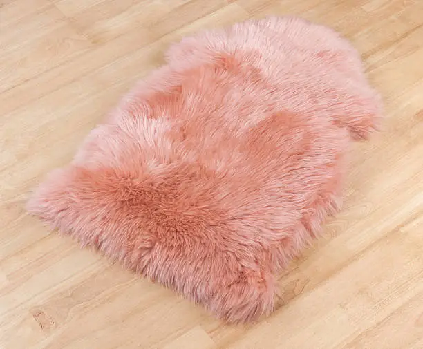 Decorative fur carpet on wooden floor