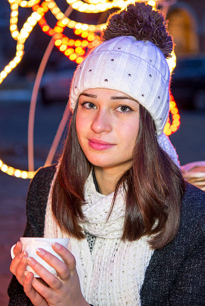 istock beautiful girl sitting outdoors in winter with a cup 537076517