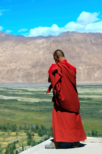 Buddhist monk against mountains in the Himalayas