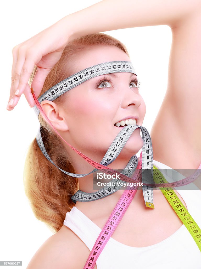 Obsessed fitness woman with a lot of colorful measure tapes Time for diet slimming weight loss. Health care healthy lifestyle. Fit fitness woman with a lot of colorful measure tapes around her head. Obsessed girl by body. 2015 Stock Photo