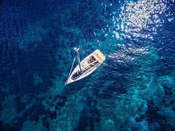 Anchored sailboat, view from drone Anchored sailboat, high angle view from drone Phantom 3. Model released. anchored photos stock pictures, royalty-free photos & images