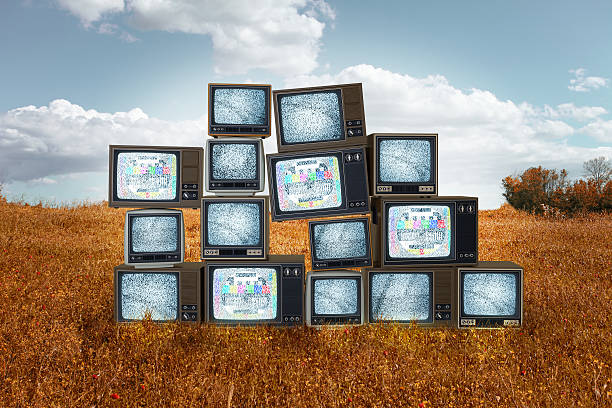 istock Old televisions stacked in the middle of grass field 537094131