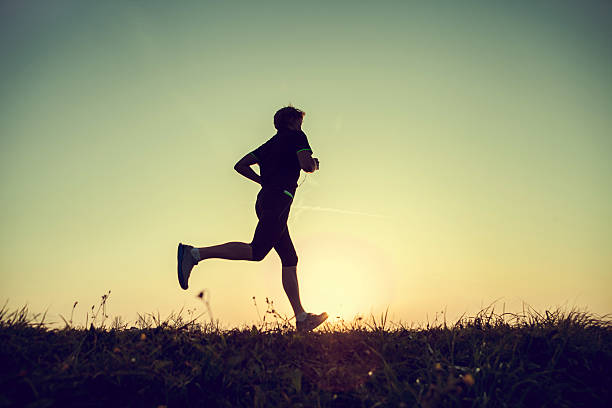istock Running man silhouette in sunset time 537095423
