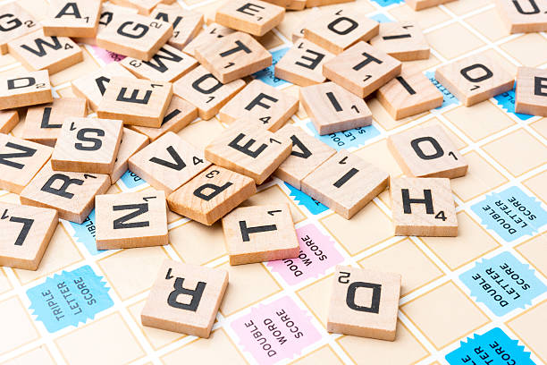 Scrabble Letters Miami, Florida, USA - June 22, 2014: Lettered wooden tiles mixed up on Scrabble game board. Scrabble is a fun and educational game distributed by Hasbro word game stock pictures, royalty-free photos & images