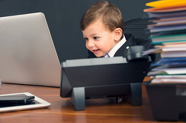 istock Humorous image of young boy working on a laptop computer 537099603