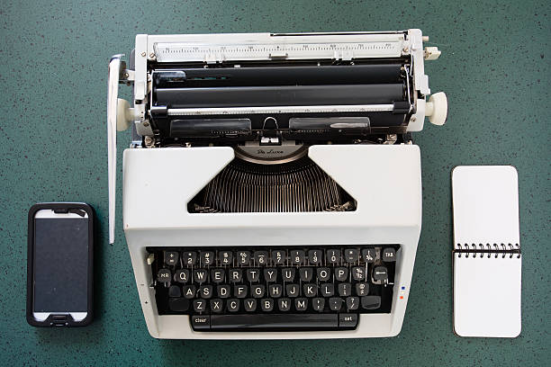 istock Portable typewriter, circa 1970, with notepad and smartphone 537104582