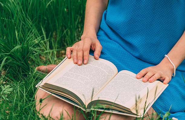 istock Woman reading a book in summer park 537114259