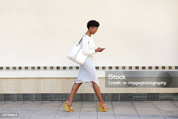 歩いて若い女性テキストメッセージを携帯電話用 - 歩くのストックフォトや画像を多数ご用意 - 歩く, 女性, 女性一人