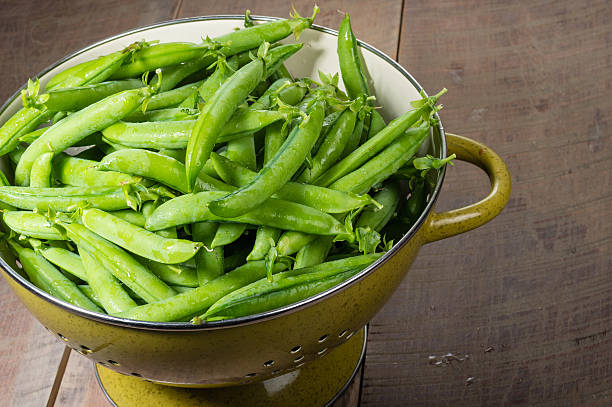 istock Fresh green pea pods in a bowl 537117239