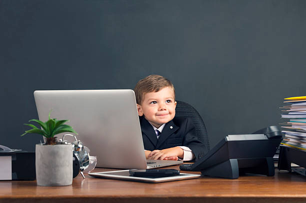 ユーモラスな画像の少年、ノートパソコンでの作業 - concentration teacher business copy space ストックフォトと画像