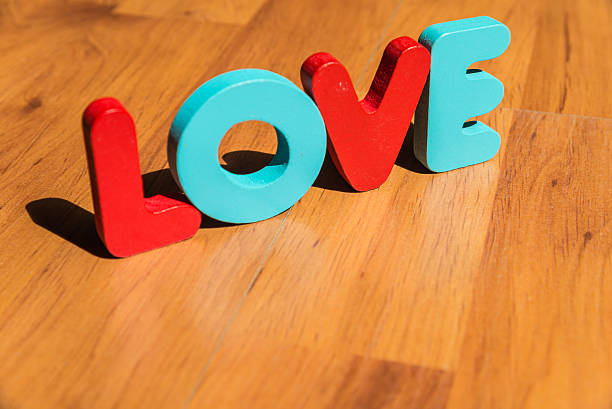 istock Wooden word LOVE on laminate floor in bright style 537120411