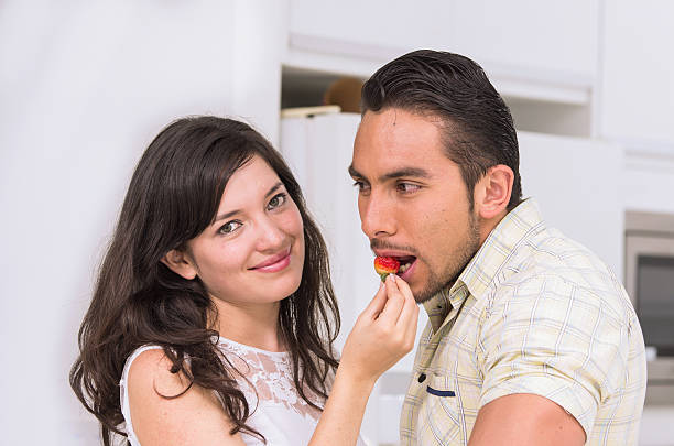 istock cute happy couple feeding each other a strawberry 537176337