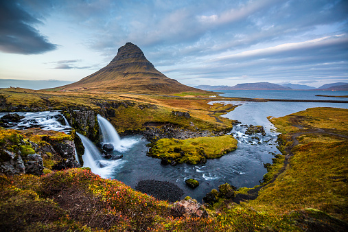 Iceland landscape with waterfall and beautiful Kirkjufell mountain at dusk
