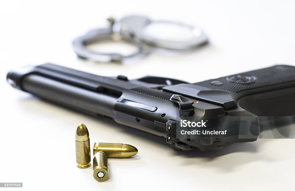 Gun, bullets and handcuffs on white background 2015 Stock Photo