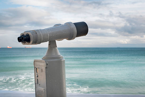 istock sea binoculars by the sea shore. working with coins. 537177479