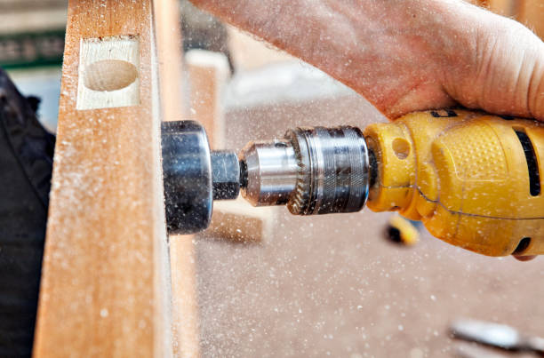 istock Hang a door, carpenter drillings lock latch hole, close-up. 537183910