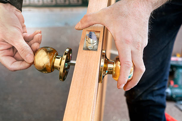 Install interior door, joiner mount knob with lock, hand close-up. Door installation, worker Installs door knob, woodworker hands close-up. doorknob photos stock pictures, royalty-free photos & images