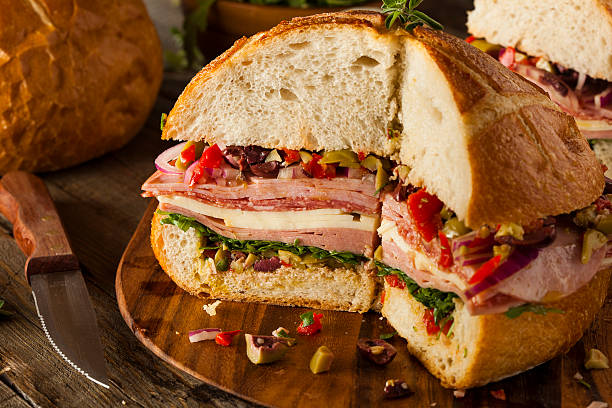 Cajun Muffaletta Sandwich with Meat and Cheese Cajun Muffaletta Sandwich with Meat Olives and Cheese baloney photos stock pictures, royalty-free photos & images