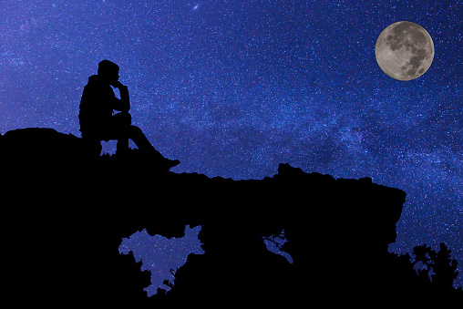 Young man sitting under the stars