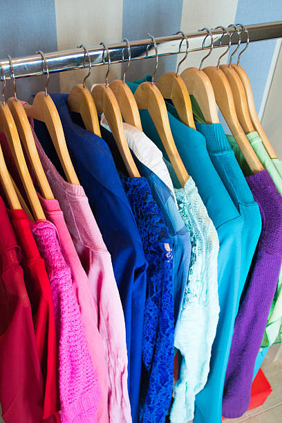 Closeup on color coordinated clothes on hangers