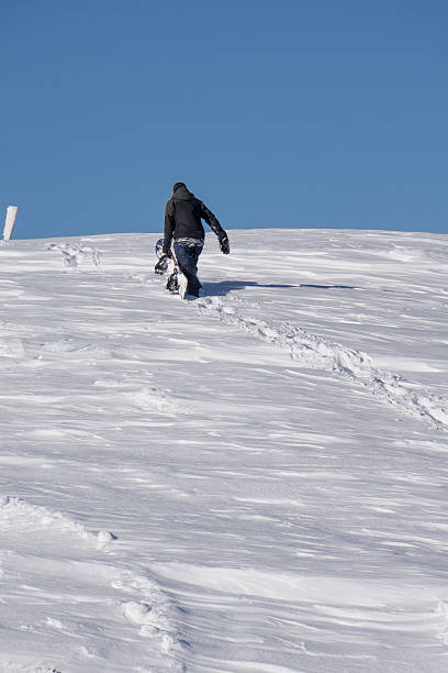 istock Snowboarder climbing a snowy mountain 537189857