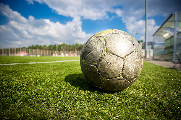 istock old soccer ball on grass field at sunny day 537189897