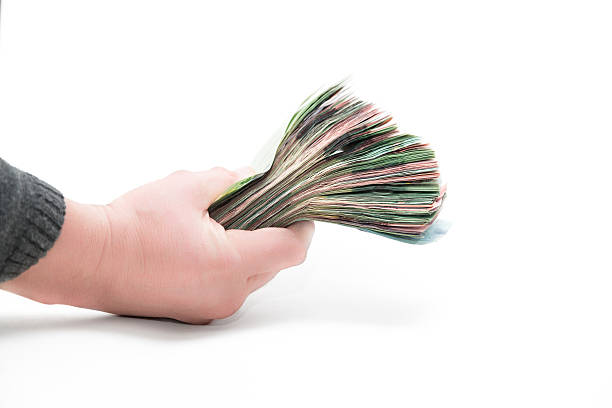 istock hand holding thick pack of money banknotes isolated on white 537190609