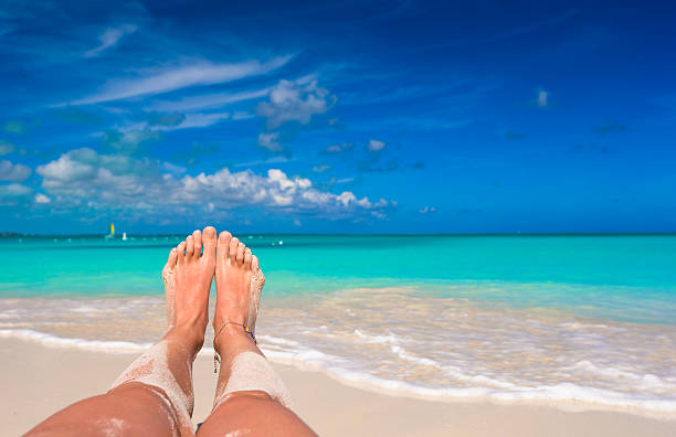 istock Female feet on white sandy beach 537191229