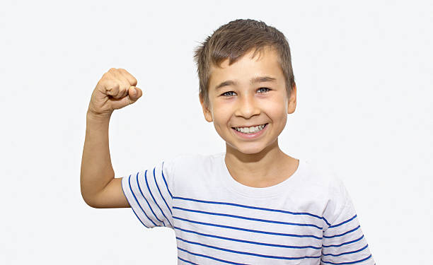 ritratto di piccolo ragazzo mostrando il suo bicipite su sfondo bianco - flexing muscles child little boys bicep foto e immagini stock